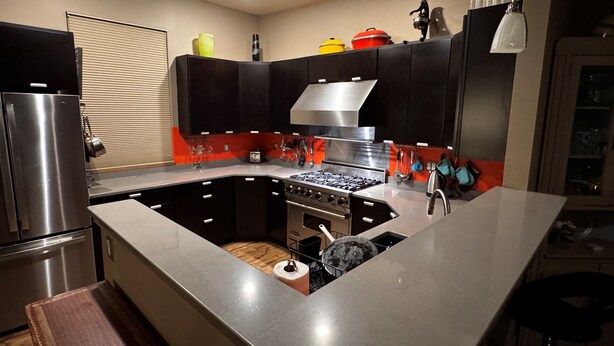 A modern kitchen with a stainless steel refrigerator, a built-in oven, and a gas stove. - The Crag: On the Acadia National Park Border - Deck, Fire Pit, Steps to Trails (Mount Desert)