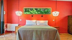 A room with a bed, two bedside lamps, a radiator, a chair, and a framed picture on the wall. - The Crag: On the Acadia National Park Border - Deck, Fire Pit, Steps to Trails (Mount Desert)