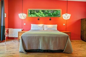 A room with a bed, two bedside lamps, a radiator, a chair, and a framed picture on the wall. - The Crag: On the Acadia National Park Border - Deck, Fire Pit, Steps to Trails (Mount Desert)