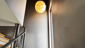 A staircase with zebra-patterned steps, a metal railing, and a hanging light fixture. - The Crag: On the Acadia National Park Border - Deck, Fire Pit, Steps to Trails (Mount Desert)
