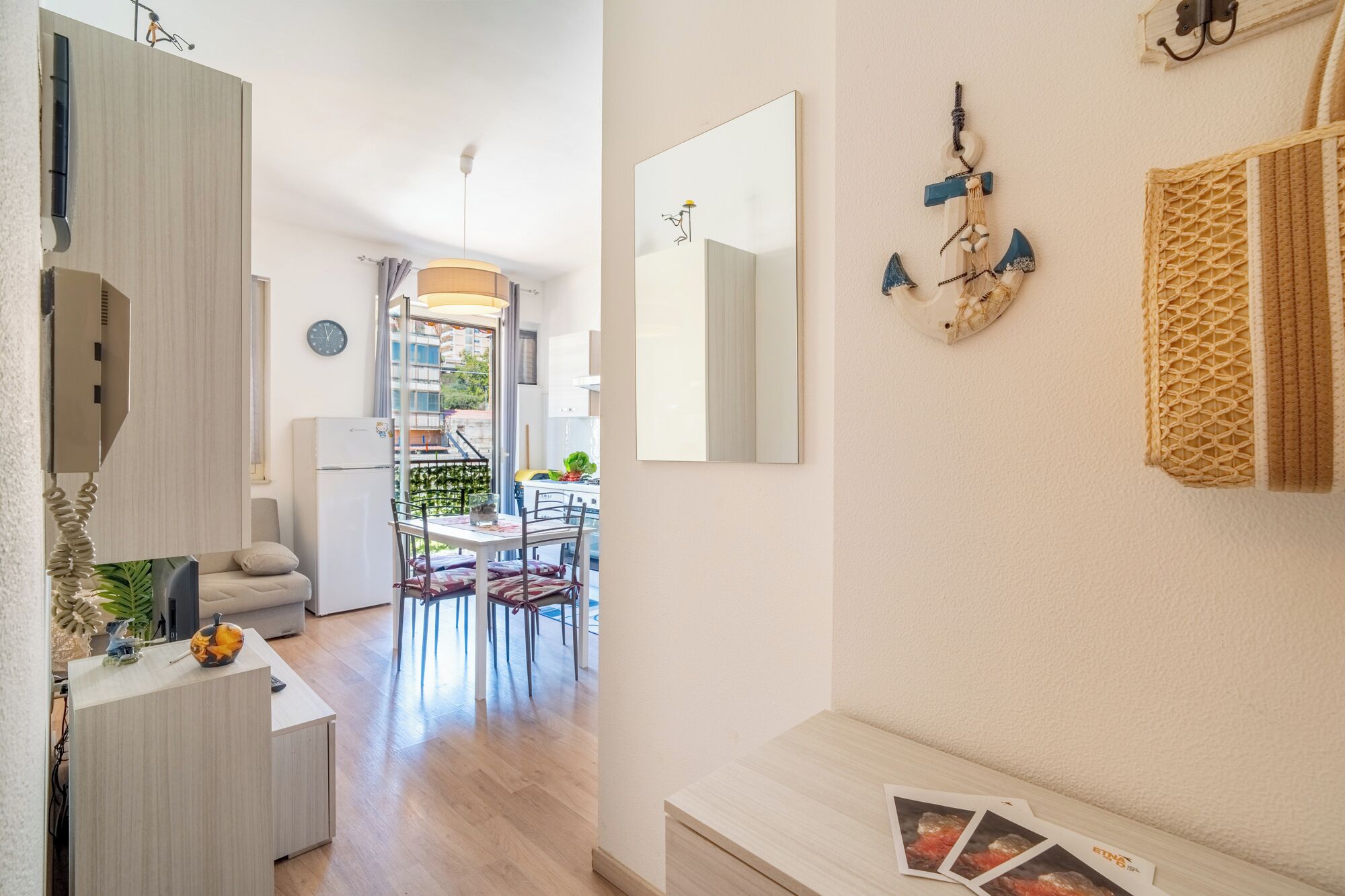 Una cocina moderna con comedor, un espejo grande y una pequeña mesa con revistas.
