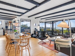 Un espace de vie spacieux comprenant une grande table à manger, des sièges confortables et une vue sur l’extérieur.
