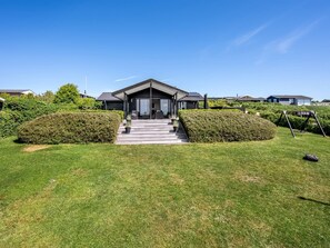 A modern house with a front porch, steps leading to the entrance, and a well-maintained lawn. - "Gertina" - 100m from the sea by Interhome (Knebel)