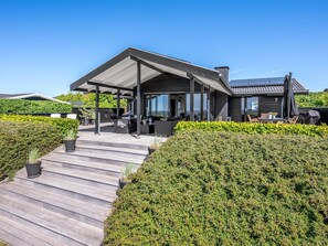 A modern house with a covered patio, a deck, and a well-maintained garden. - "Gertina" - 100m from the sea by Interhome (Knebel)