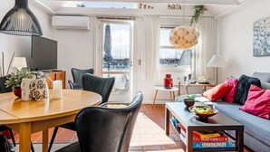 Un moderno salón con comedor, ventanas amplias y vista al puerto deportivo.