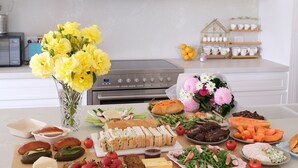 A kitchen counter with various food items and a vase of yellow flowers. - Waterfront retreat w/private dock, kayaks & animal encounters (Tooradin)