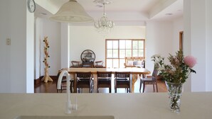 A dining area with a chandelier, wooden table, chairs, and a vase with flowers. - Waterfront retreat w/private dock, kayaks & animal encounters (Tooradin)