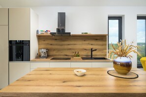 Una cocina moderna con encimera de madera, un fregadero y un jarrón sobre la mesa.