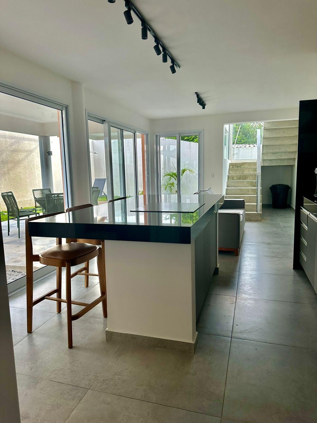 Una cocina moderna con una isla central, ventanas amplias y vistas al exterior.