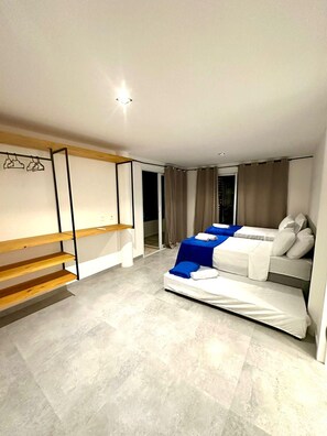A modern bedroom with a bed, a wooden bench, and a wardrobe.