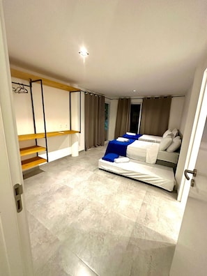 Un dormitorio moderno con una cama, un armario y una estantería empotrada.