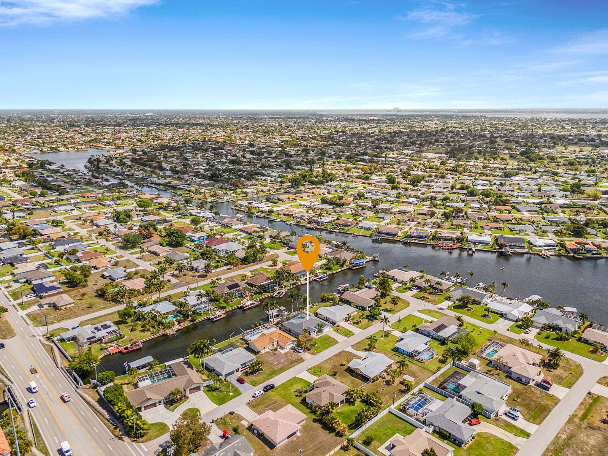 Vista aerea di una zona residenziale con case, un fiume e una strada.