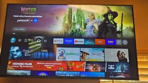A television screen displaying a Disney+ interface with various streaming service logos and a promotional banner for 'Wicked' on Netflix.