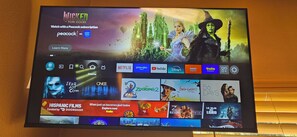 A television screen displaying a Disney+ interface with various streaming service logos and a promotional banner for 'Wicked' on Netflix.