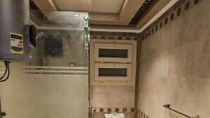 Un baño pequeño con inodoro, lavadora e insonorizado para la ducha.