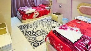 Un dormitorio con dos camas, un tapete estampado e iluminación empotrada en el techo.