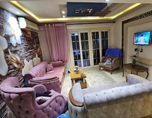 A living room with a sofa set, a coffee table, a TV, and a patterned rug. - Luxury Flat In Miami With Panoramic sea Views (Alexandria)