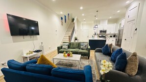 Een moderne woonkamer met een bank, salontafel en een flatscreen televisie.