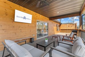 A covered outdoor seating area with wooden walls, a sign reading 'RENTBR BRINSON.COM', and a view of the surrounding landscape. - Tall Timbers Cabin Right Across Community Pools_Free Daily Tickets_Near Thunder Ridge (Hollister)