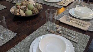A dining table set with plates, glasses, and cutlery, with a bowl of decorative items on the side. - Spacious 4-master-suite condo in charming St. George (St. George)