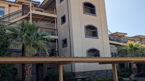 A multi-story building with balconies, a parking area, and a covered walkway. - Spacious 4-master-suite condo in charming St. George (St. George)