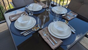 A table set for four with plates, glasses, and cutlery, outdoors with chairs and a railing. - Spacious 4-master-suite condo in charming St. George (St. George)