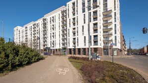 Ein mehrstöckiges Wohngebäude mit Balkonen, einer Fahrradspur und blauem Himmel.