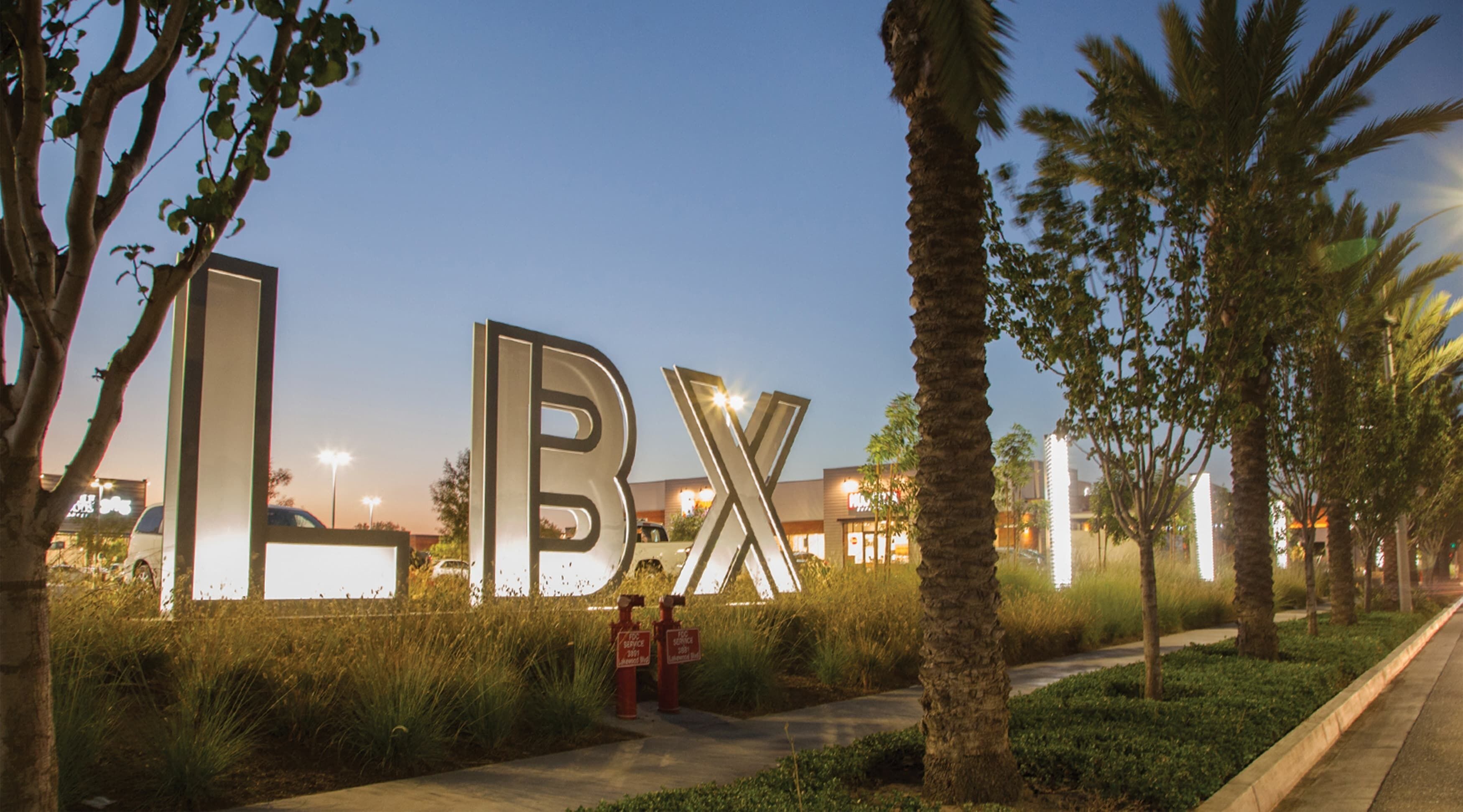 A landscaped area with large illuminated letters spelling 'BX' and a pathway.