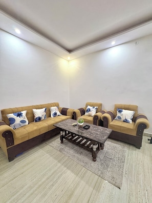 A living room with a sectional sofa, a coffee table, and a patterned rug.