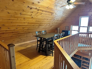 A wooden interior with a dining table and chairs, a ceiling fan, and a view through a window. - peaceful Northwoods retreat on quiet Crystal Lake (Gordon)