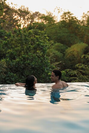 A couple in a hot tub surrounded by greenery. - Garden Heights Studio at Taru Rentals (Montezuma)