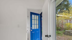 Una puerta azul que da a un cuarto con ventana.
