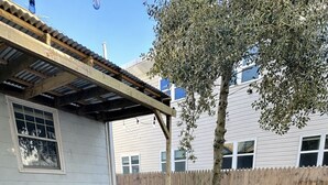 En træterrasse med udendørs møbler og et spabad.