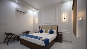 Une chambre d’hôtel comprenant un lit, des tables de chevet, un bureau et une chaise.