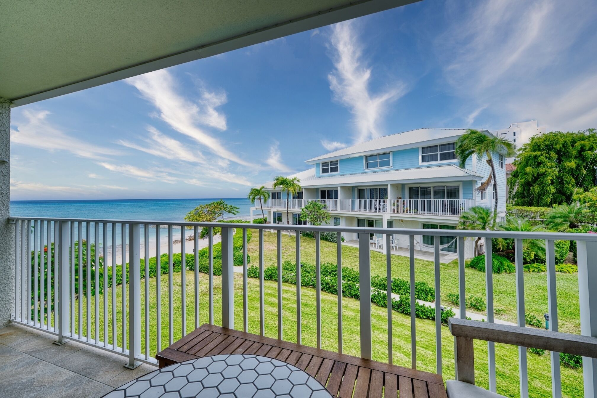 Ein Strandgrundstück mit Balkon, Pool und Meerblick.