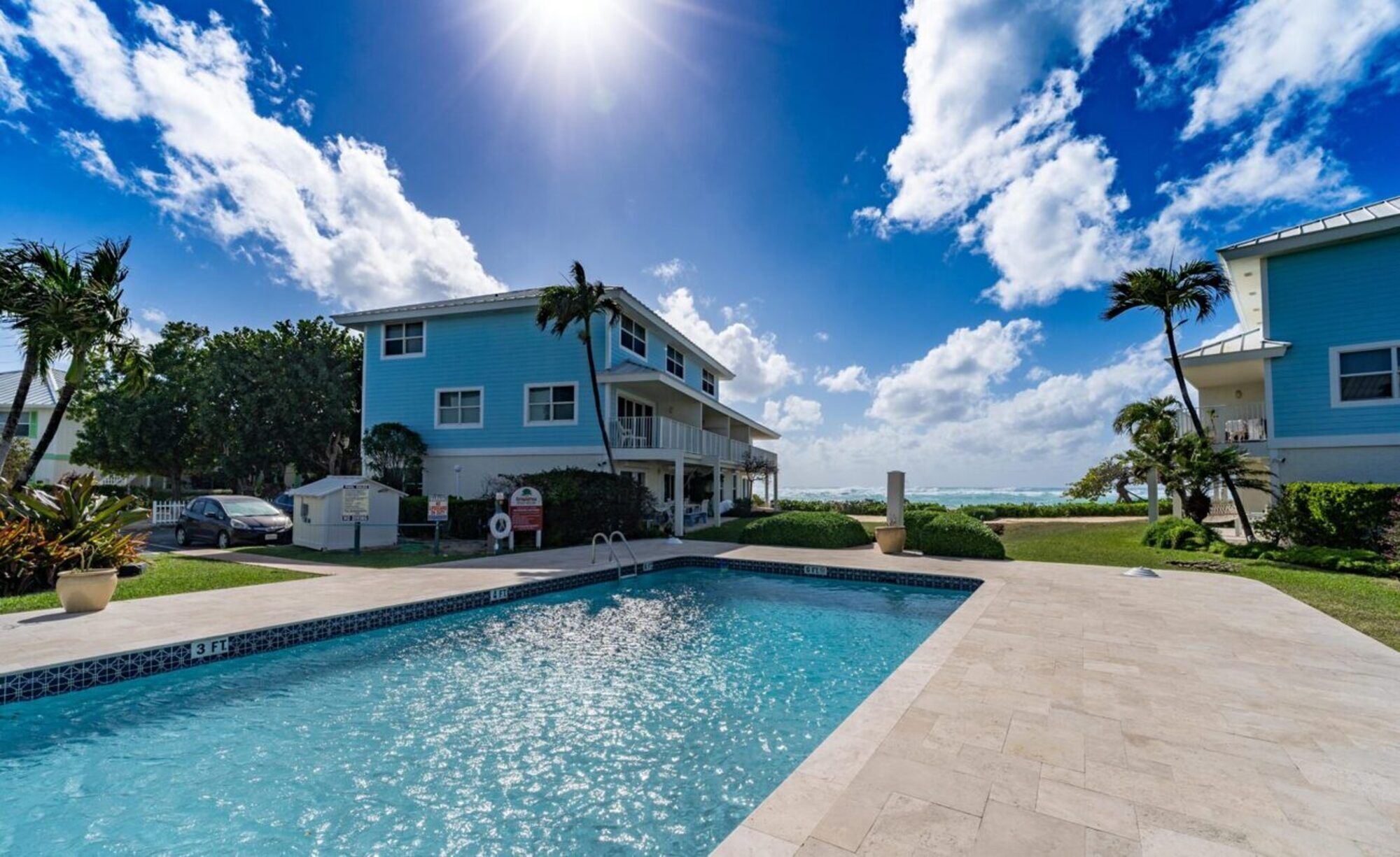 A two-story building with a swimming pool in front.