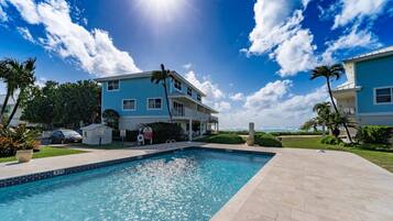 A two-story building with a swimming pool in front.
