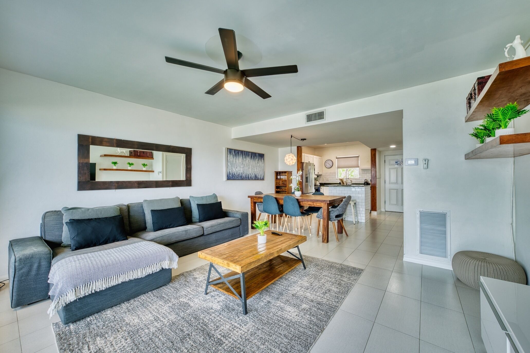 A modern living room with a sofa, coffee table, and dining area.