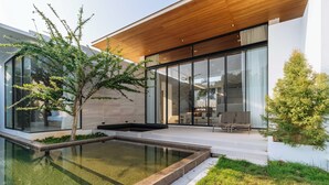 A modern house with a swimming pool, large windows, and a wooden ceiling. - New Prime Location Near Boat Avenue V306 (Choeng Thale)