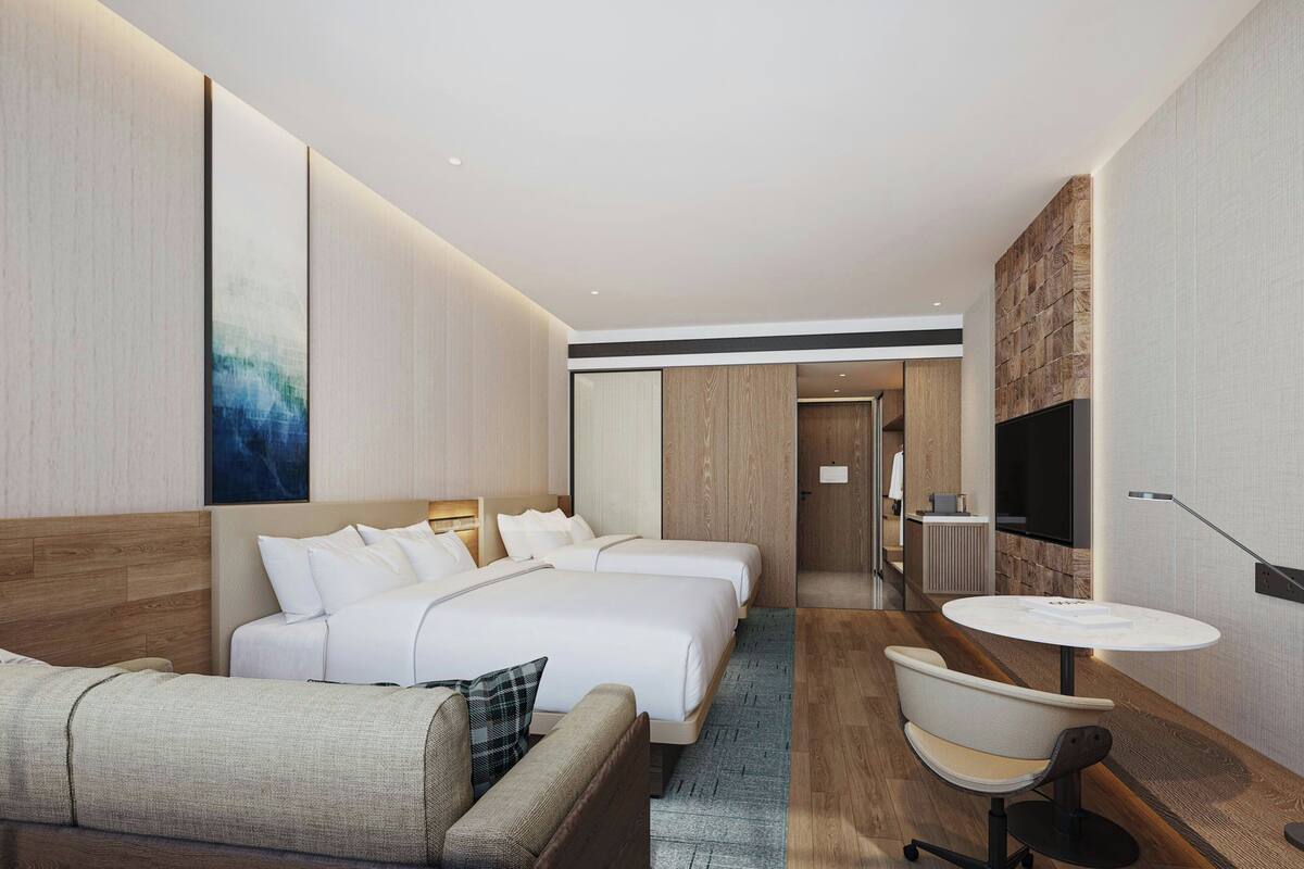 Een moderne hotelkamer met een groot bed, een bank, een tafeltje en een televisie.
