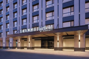 Un hôtel à plusieurs étages, doté d’une façade moderne, de grandes fenêtres et d’une entrée imposante.