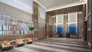 Eine moderne Lobby mit Empfangstresen, Sitzgelegenheiten und großen Fenstern.