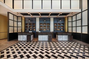 A lobby with a checkered floor, two reception desks, and a wall with display cabinets. - Four Points By Sheraton Rizhao Central Activities Zone (Rizhao)