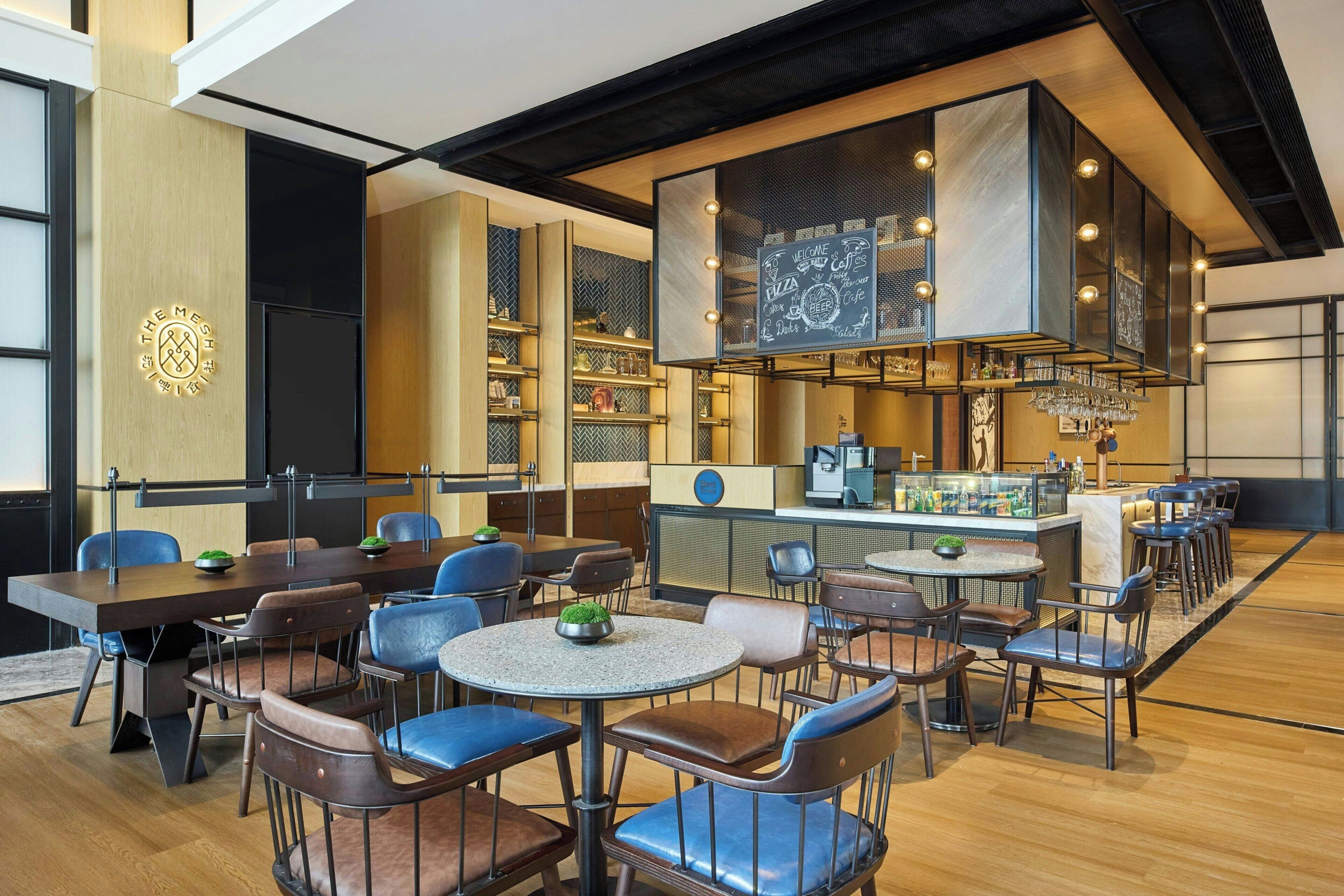 A modern restaurant interior with a bar area, seating arrangements, and a chalkboard menu.