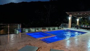 A swimming pool with a view of the mountains at night.