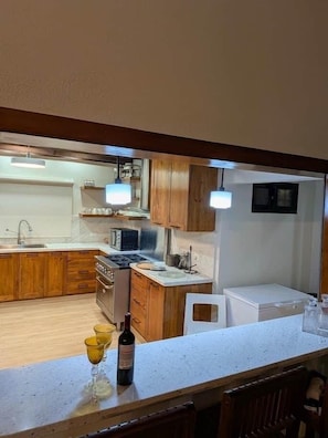 Una cocina con armarios de madera, una encimera, un lavabo y una estufa.
