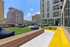 A rooftop terrace with seating, a small garden, and modern buildings in the background. - Cozy Murphy Hideaway Studio 18th (Birmingham)