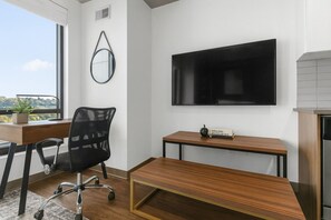 A modern office space with a desk, chair, and a mounted TV. - Cozy Murphy Hideaway Studio 18th (Birmingham)