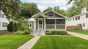 A two-story house with a front porch, a covered porch area, and a small front yard.