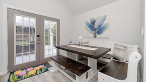 A dining area with a bench, a table, and a door with glass panels.